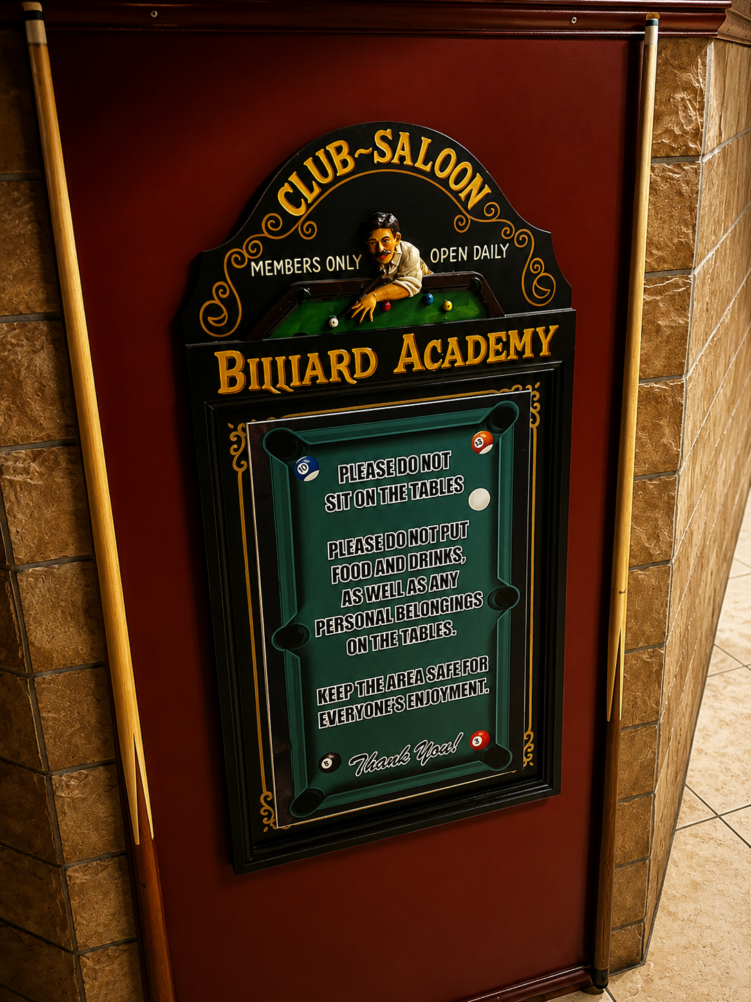 Vintage-style billiard academy sign mounted between cue sticks