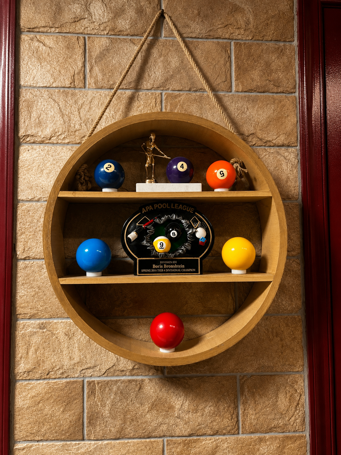 Decorative shelf featuring billiards trophies and pool balls